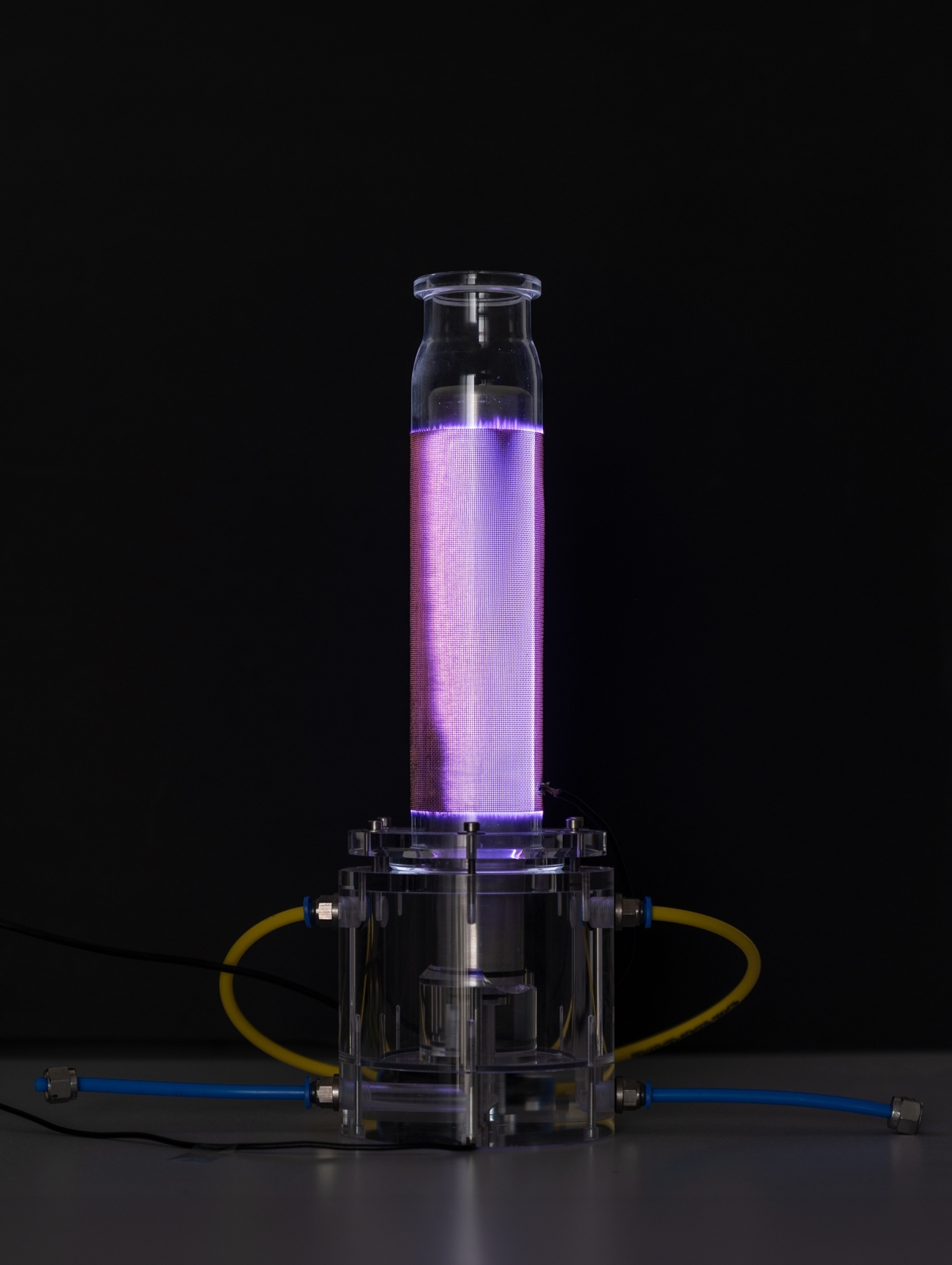 Plasmareaktor, in einem dunklen Raum, lila-bläulich leuchtend