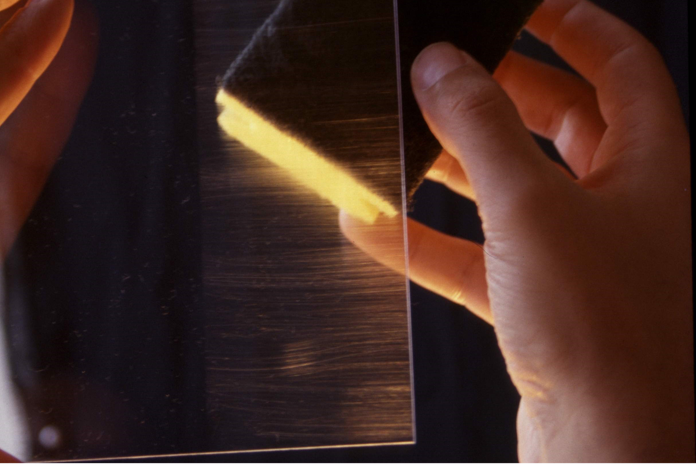 Transparent pane shows scratch marks from a rinsing sponge on the right half, while the left side of the pane shows no scratches due to a scratch protection layer.